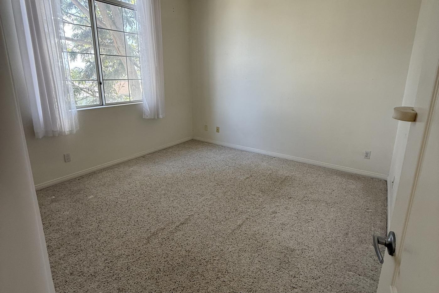 Empty bedroom with vaulted ceiling before the work